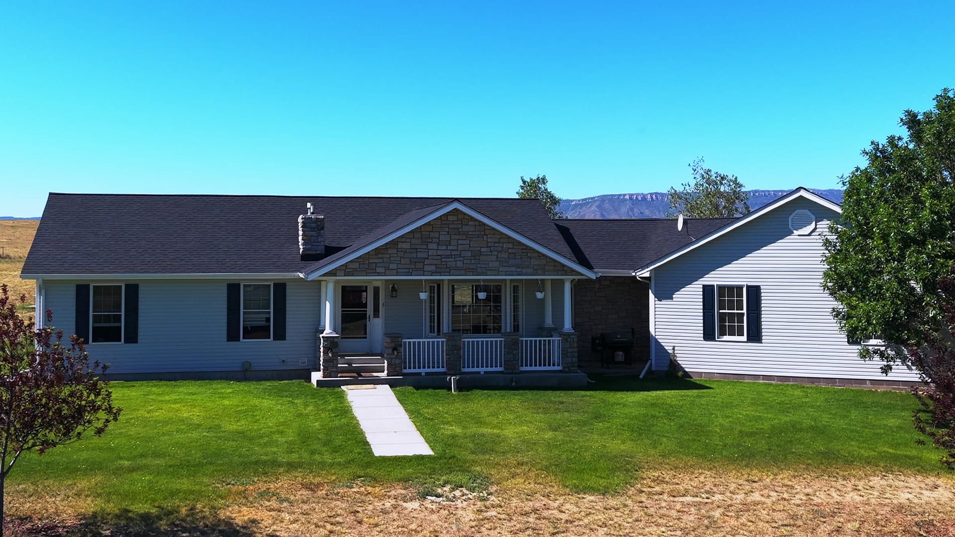Aerial front view of a ranch home outside Casper, Wyoming with mountains behind