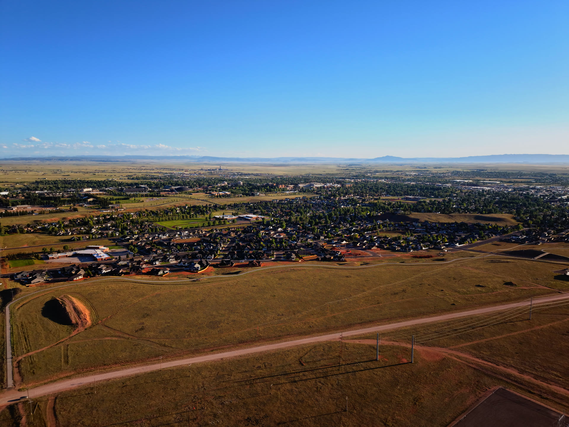 High aerial drone photo of Laramie, Wyoming with prairie and mountains in the distance